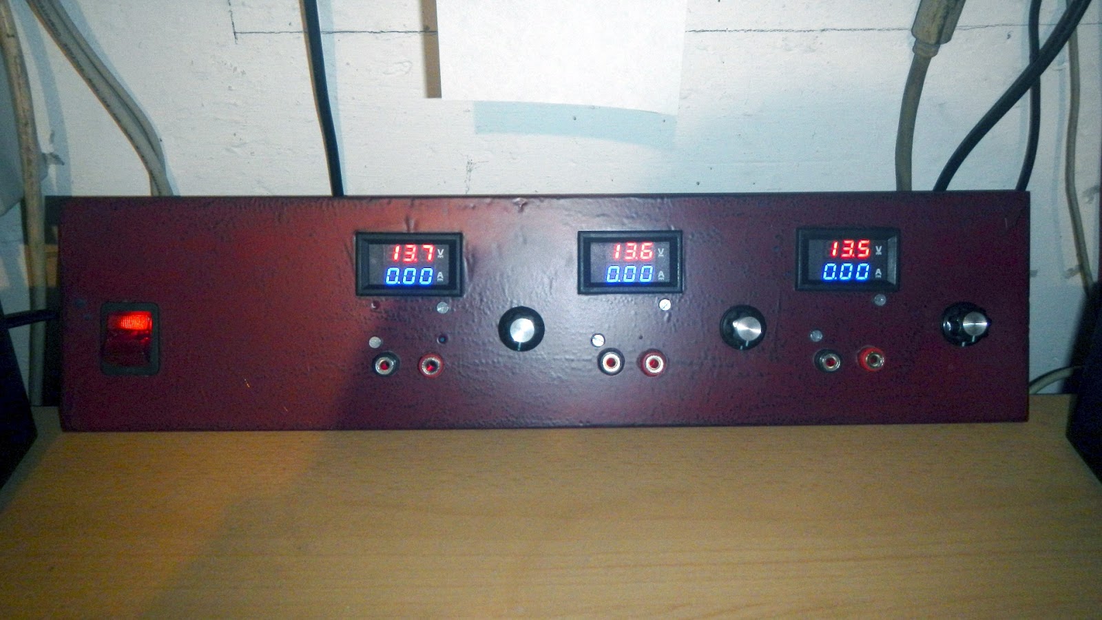 Front panel of the power supply with three channels, each with a volt/ammeter, potentiometer and binding posts